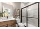Modern bathroom featuring a wood vanity, marble-tiled shower, and updated fixtures at 5270 Birch Valley Rd, Cumming, GA 30028