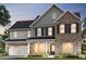 Two-story brick home with gray shake siding and a three-car garage at 5270 Birch Valley Rd, Cumming, GA 30028