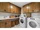 Well-organized laundry room with front-loading washer, dryer, and ample cabinet space for storage at 5270 Birch Valley Rd, Cumming, GA 30028