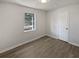 Simple bedroom with grey vinyl plank flooring and a large window at 9129 Bent Pine Ne Ct, Covington, GA 30014