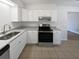 Well-lit kitchen featuring white cabinets, updated stainless steel appliances, and laminate countertops at 9129 Bent Pine Ne Ct, Covington, GA 30014