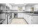 Well-lit kitchen features stainless steel appliances, granite countertops, and ample white cabinetry at 23 Chelsea Ct, Avondale Estates, GA 30002