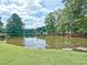 Reflective pond with trees surrounding the property, offering a serene and picturesque view at 23 Chelsea Ct, Avondale Estates, GA 30002