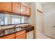 Functional kitchen featuring stainless steel sink, black countertops, and wood cabinets with dishwasher at 1250 Parkwood Se Cir # 1004, Atlanta, GA 30339