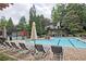 Resort-style community pool with lounge chairs, umbrellas, and nearby tennis court at 1250 Parkwood Se Cir # 1004, Atlanta, GA 30339