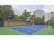 This a tennis court with trees and a stone retaining wall in the background at 1250 Parkwood Se Cir # 1004, Atlanta, GA 30339