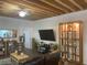 Living room with exposed wooden beams, hardwood floors, and a large TV at 200 Heath Rd, Carrollton, GA 30116
