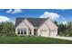 Charming single-story home with a brick facade, well-manicured lawn, and two-car garage at 6540 Namon Creek Trl, Cumming, GA 30028