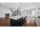 Modern kitchen with a large island, stainless steel appliances, and a view into the living room at 6540 Namon Creek Trl, Cumming, GA 30028