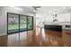 Open-concept living room with hardwood floors, large sliding doors to the backyard, and a kitchen view at 6540 Namon Creek Trl, Cumming, GA 30028