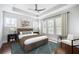Bright main bedroom featuring hardwood floors, a tray ceiling, and large windows at 6540 Namon Creek Trl, Cumming, GA 30028