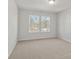 Bright bedroom with neutral carpeting and two large windows at 714 Smokey Quartz Way, Kennesaw, GA 30144