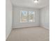 Bright bedroom featuring neutral walls, plush carpeting, and two windows offering serene views at 714 Smokey Quartz Way, Kennesaw, GA 30144