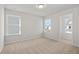Bedroom with neutral carpeting, two windows, and access to another room at 714 Smokey Quartz Way, Kennesaw, GA 30144