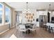 Bright dining room with modern chandelier, wood floors and stainless steel kitchen appliances at 714 Smokey Quartz Way, Kennesaw, GA 30144