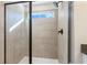 Walk-in shower featuring gray tiled walls, black hardware, and a frameless glass door at 714 Smokey Quartz Way, Kennesaw, GA 30144