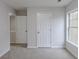 This bedroom offers neutral carpet, a double hung window, and two closets at 1886 Carisbrook Pl, Austell, GA 30168