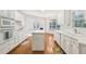 White kitchen with center island, ample cabinetry, and hardwood floors at 135 Eagles Club Dr, Stockbridge, GA 30281