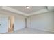 Neutral-toned bedroom features a trey ceiling, and two open doorways with the view of wood-look flooring at 4361 Portsbrook Ave, Snellville, GA 30039
