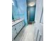 Bright blue bathroom featuring a tub/shower, sink with vanity, neutral rug, and textured ceiling at 571 Oak Vista Ct, Lawrenceville, GA 30044