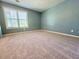 Neutral bedroom with plush carpeting and large window providing natural light at 571 Oak Vista Ct, Lawrenceville, GA 30044