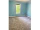 Bright bedroom with a large window and neutral carpet flooring at 571 Oak Vista Ct, Lawrenceville, GA 30044