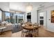 Bright living room with hardwood floors, a modern chandelier, and expansive windows showcasing city views at 3325 Piedmont Ne Rd # 2407, Atlanta, GA 30305