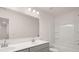 Bathroom featuring a double sink vanity, large mirror, and tub with white shower at 13520 Whitman Lane, Covington, GA 30014