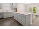 This well-lit kitchen features grey cabinets, an island with a white countertop, and wood-look floors at 13520 Whitman Lane, Covington, GA 30014