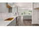 A bright kitchen has gray cabinets, white countertops, wood-look floors, and stainless steel appliances at 13520 Whitman Lane, Covington, GA 30014