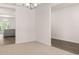 A bright living room features neutral carpeting, a modern chandelier, and an opening to an adjacent space at 13520 Whitman Lane, Covington, GA 30014