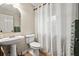 Clean bathroom with pedestal sink, toilet and window at 44 Browns Ct, Powder Springs, GA 30127