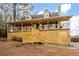 Green house with a wrap-around porch and wood deck at 44 Browns Ct, Powder Springs, GA 30127