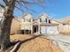 Two-story house with stone and beige accents, a two-car garage, and a tree in front at 585 Briarhurst Ct, Lawrenceville, GA 30046