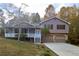 Two-story house with brown siding, white porch, and attached two-car garage at 1129 Gate Post Ln, Lawrenceville, GA 30044
