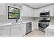 Modern white kitchen with stainless steel appliances and quartz countertops at 1129 Gate Post Ln, Lawrenceville, GA 30044