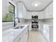 Modern white kitchen with stainless steel appliances and quartz countertops at 1129 Gate Post Ln, Lawrenceville, GA 30044