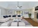 Virtually staged living room with L-shaped sofa and stone fireplace at 1129 Gate Post Ln, Lawrenceville, GA 30044
