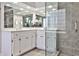 Modern bathroom with glass shower, double vanity, tile accents, and white cabinets at 6355 Indian Acres Trl, Tucker, GA 30084