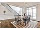 This formal dining room features hardwood floors with an adjacent staircase and large windows at 6355 Indian Acres Trl, Tucker, GA 30084