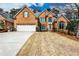 Traditional two-story brick home featuring a well-manicured lawn and attached two-car garage at 6355 Indian Acres Trl, Tucker, GA 30084