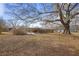 View of large backyard, back patio, and mature trees with foliage at 1155 Casteel Rd, Powder Springs, GA 30127