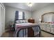Bedroom with a window, ceiling fan, wood dresser, and blue and white bedding at 1155 Casteel Rd, Powder Springs, GA 30127