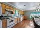 Bright kitchen with wood cabinets, white appliances, and hardwood floors at 1155 Casteel Rd, Powder Springs, GA 30127