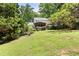 Spacious backyard with mature trees and fire pit area at dusk at 6006 Lanier Heights Cir, Buford, GA 30518