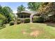 View of the back of the house showcasing an expansive yard with a screened in porch at 6006 Lanier Heights Cir, Buford, GA 30518