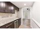 Chic wet bar features granite counters, dark wood cabinets, and wine fridge at 6006 Lanier Heights Cir, Buford, GA 30518