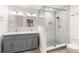 Bathroom featuring gray vanity with double sinks, granite countertop, updated lighting and glass door shower at 6006 Lanier Heights Cir, Buford, GA 30518