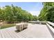 View from the lake of a large wooden deck with chairs stacked, showcasing outdoor living space at 6006 Lanier Heights Cir, Buford, GA 30518