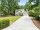 Exterior view of two-story home with a long driveway and a well-manicured lawn at 6006 Lanier Heights Cir, Buford, GA 30518